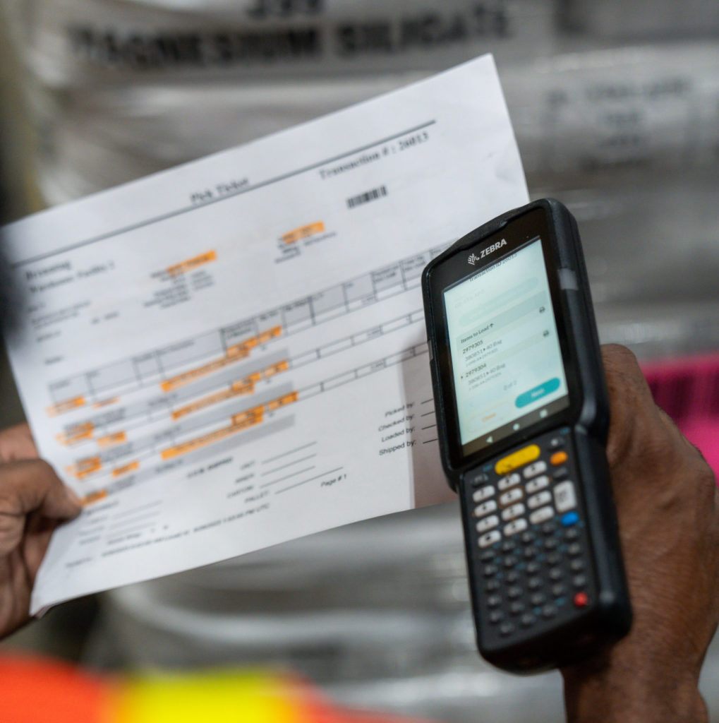 Worker holding scanner with 3PL tracking sheet